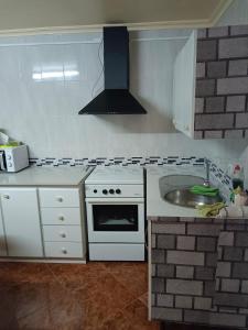 uma cozinha com um fogão branco e um lavatório em Casa rural Mccoy em Macael