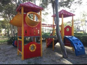 a playground with a slide and a play structure at Campeggio 2 Mari in Ovile la Marinella