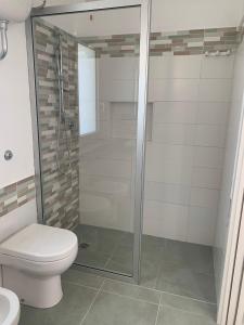 a bathroom with a toilet and a glass shower at Campeggio 2 Mari in Ovile la Marinella +22 photos