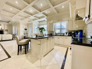 a large kitchen with white cabinets and a ceiling at Vancouver Airport guesthouse in Vancouver