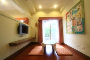 een woonkamer met een tafel en een raam bij Malia Homestay in Hualien
