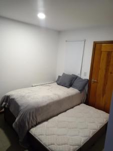1 dormitorio con 1 cama y puerta de madera en Hermoso Departamento Céntrico en San Martin de los Andes en San Martín de los Andes