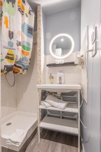 a small bathroom with a sink and a refrigerator at Résidence Les Cordeliers in Avignon