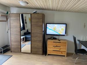 a living room with a television and a mirror at Idyliska boende mitt på Öland in Färjestaden