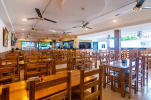 uma sala de jantar cheia de mesas e cadeiras de madeira em Hotel Cuchara de Palo Ayenda em Santa Marta