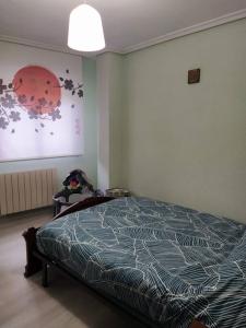 1 dormitorio con 1 cama y una pintura en la pared en Atico en Torrecilla en Cameros, en Torrecilla en Cameros