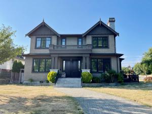 een groot huis met een veranda en een oprit bij Vancouver Luxury Guest House in Vancouver