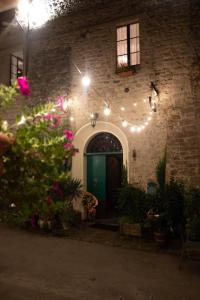 a brick building with a green door and lights at Affittacamere la Torre in Marzabotto