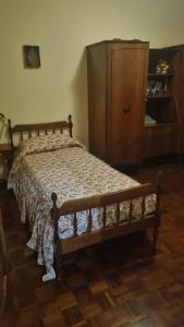 a bedroom with a wooden bed with a wooden dresser at Viale Ancona by Ospitaci in Foligno