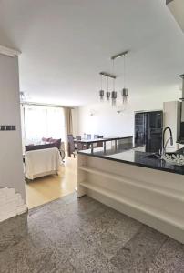a kitchen with a counter top and a living room at Apartament z małym spa in Gdynia