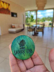 a person holding a green button that says yanyon be at Quinta YaaxBe in Homún