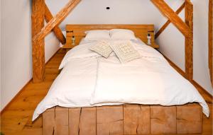 een groot bed met witte lakens en kussens erop bij 2 Bedroom Gorgeous Apartment In Mozirje in Mozirje