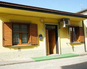 a yellow house with wooden windows and a door at LE MIMOSE in Spezzano Albanese