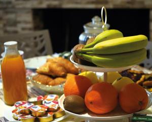 LE MIMOSE في Spezzano Albanese: صحن من الفواكه مع الموز والبرتقال على طاولة