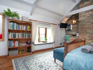 Railway Cottage في كاميلفورد: غرفة نوم مع سرير ورف كتاب