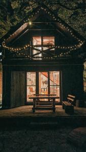 a house with a picnic table and lights on it at Rent a Forest, Cabin Hidden in the Fruška gora in Velika Remeta