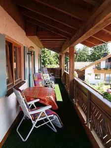 eine Veranda mit Stühlen und einem Tisch auf dem Balkon in der Unterkunft Gästehaus Kerpf inclusive KönigsCard in Nesselwang