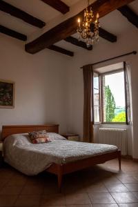 a bedroom with a bed and a window and a chandelier at Affittacamere la Torre in Marzabotto