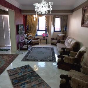 a living room with a chandelier and a couch at Aqua Tanta Group طنطا Families Only in Tanta +19 photos