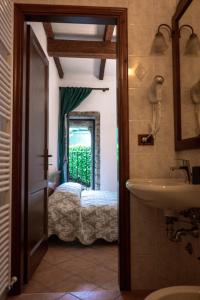 a bathroom with a sink and a door to a bedroom at Affittacamere la Torre in Marzabotto