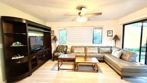 a living room with a couch and a tv at MAILAN HALE II in Kailua-Kona