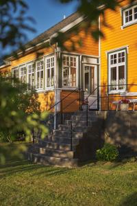 a yellow house with stairs in front of it at Hvasser Motell in Hvasser