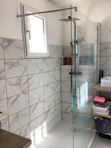 Un baño con ducha con puerta de cristal. en Maison avec jardin proche Avignon 2 chambres, en Les Angles