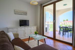 sala de estar con sofá, TV y mesa en 6 - Meraviglioso appartamento con terrazza - Sa Crai Apartments Sardinian Experience en Lotzorai