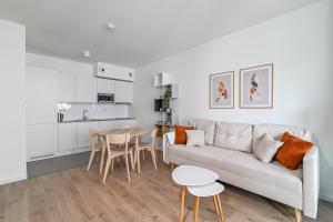 a white living room with a couch and a table at LTC - Apartments Modern Tower in Gdynia