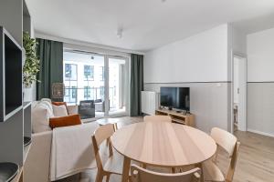 salon ze stołem i kanapą w obiekcie LTC - Apartments Modern Tower w mieście Gdynia