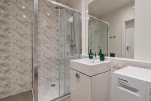 a white bathroom with a shower and a sink at LTC - Apartments Modern Tower in Gdynia +23 photos