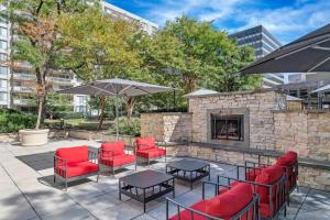 a patio with red chairs and tables and a fireplace at Fantastic 2 BR Apt + Den @Crystal City With Gym in Arlington