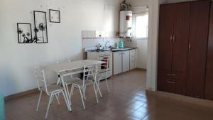 een keuken met een tafel, stoelen en een spoelbak bij APA Jazmín Sur 1 y 2 - tranquilo complejo residencial in Puerto Madryn
