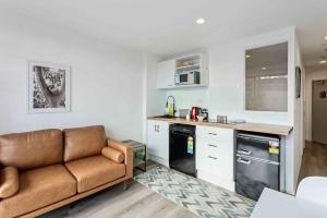 a living room with a couch in a kitchen at Cozy Two Bedroom with Seaview - Wifi - Gym in Auckland