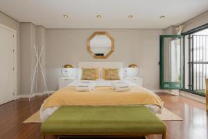 a bedroom with a large bed with a green ottoman at C30 Deluxe Studio with Terrace into Cathedral Square in Málaga