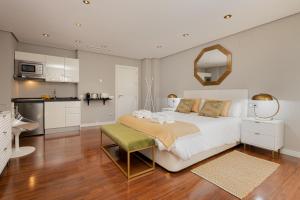 a bedroom with a large white bed and a kitchen at C30 Deluxe Studio with Terrace into Cathedral Square in Málaga