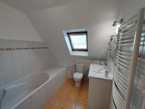 ein Badezimmer mit einer Badewanne, einem WC und einem Waschbecken in der Unterkunft Chez la Québécoise - chambre d'hôtes in Bourg-Blanc