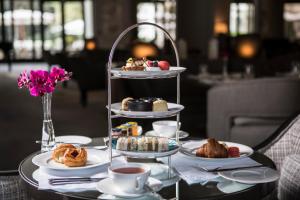 a table with a tray of pastries and cups of coffee at Palácio Tangará - an Oetker Collection Hotel in Sao Paulo