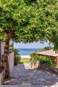 un albero con un passaggio che conduce alla spiaggia di Malsova Studio a Kotrónion