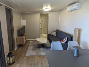 ein Wohnzimmer mit einem Sofa und einem Tisch in der Unterkunft CHALET STANDING Vue mer in Saint-Raphaël
