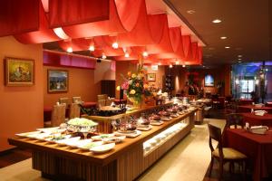 una línea de buffet en un restaurante con platos de comida en King Ambassador Hotel Kumagaya en Kumagaya