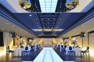 a banquet hall with tables and chairs and a large window at King Ambassador Hotel Kumagaya in Kumagaya