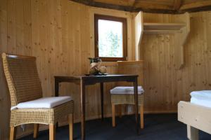 ein Esszimmer mit einem Tisch und 2 Stühlen in der Unterkunft Holzjurten by JULKA - self checkin in Finkenstein