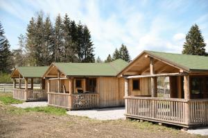 a log cabin with a green roof at Holzjurten by JULKA - self checkin in Finkenstein
