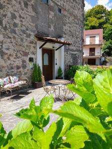 eine Terrasse mit einem Tisch und Stühlen vor einem Gebäude in der Unterkunft Il Cavallo a Dondolo in Abbadia San Salvatore