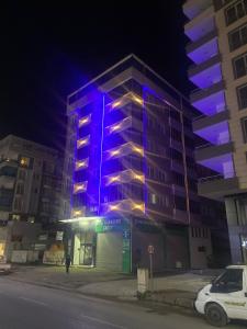 ein Gebäude mit lila Lichtern an der Seite in der Unterkunft Kıvanç Residence in Trabzon