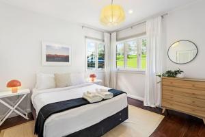 a bedroom with a large bed and a window at Renovated Character Central Home - WiFi & Netflix in Auckland