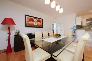 a dining room with a glass table and white chairs at Apartment Tramontana with sea view in Trogir