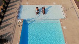 two people sitting on chairs in a swimming pool at Patriots Inn in Williamsburg