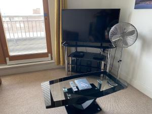 a glass table with a fan and a television at Spacious 2 Bedroom Apartment at The PostBox in Birmingham